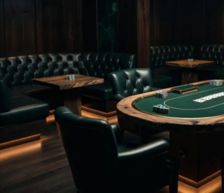 An intimate, mood-lit salon with offline poker tables and club-style seating